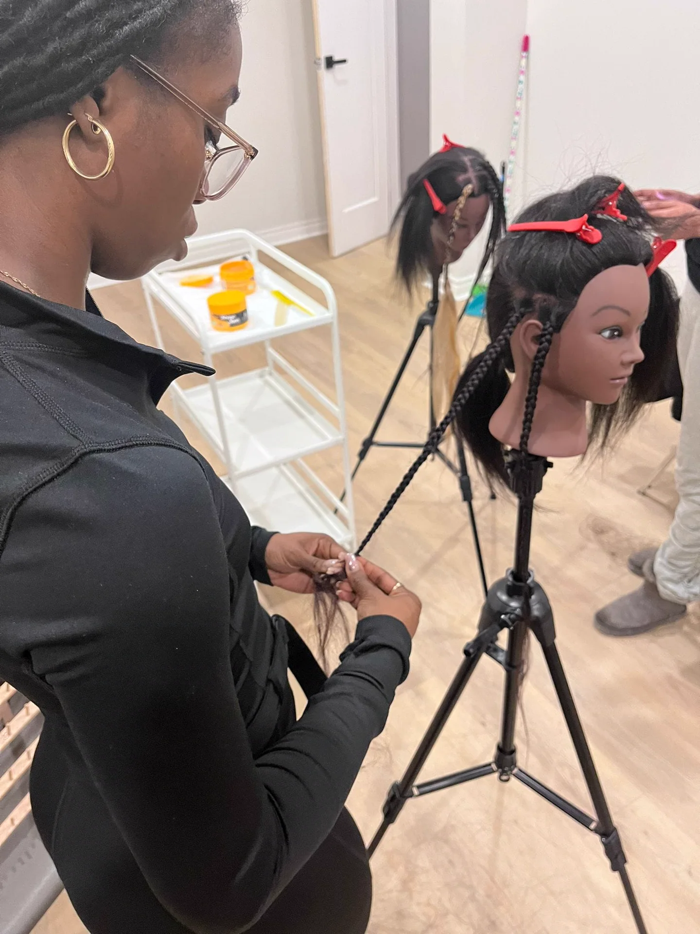 Facilitator and mannequin heads during a Skillful Hands CIC practical hair session